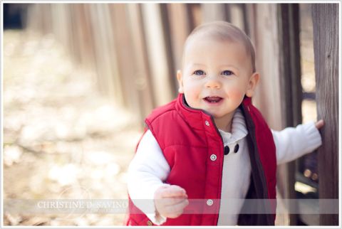 Boy in red vest holding fence - NJ Child Photographer