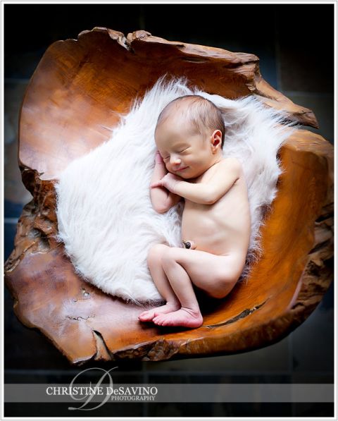 Newborn smiles on fur and wooden chair - NJ Newborn Photographer