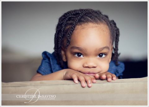 Stunning girl peeks from behind a couch - NJ Child Photographer